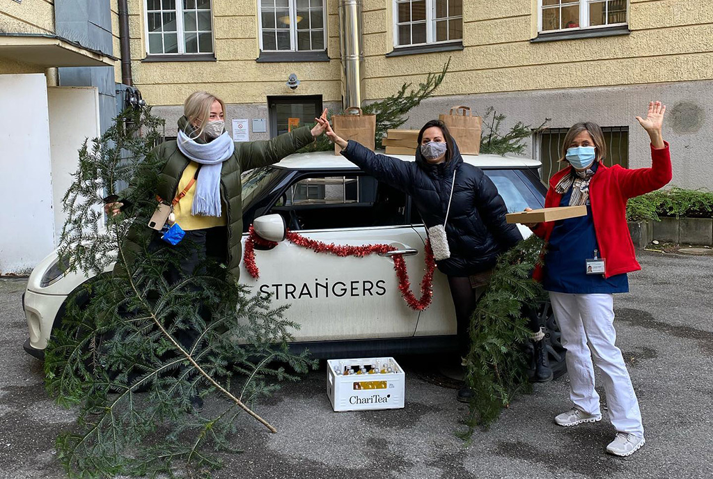 Mitarbeiter von Café Strangers vor Auto mit Geschenken