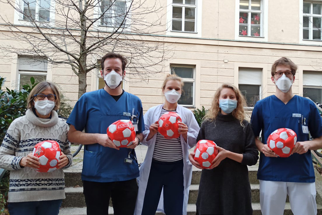 Mitarbeiter Kinderklinik und Tankstelle halten die rot-weißen Bälle in der Hand