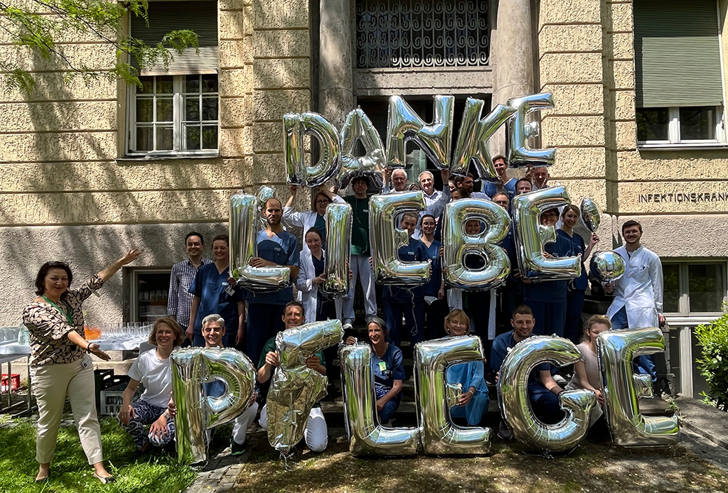 Mitarbeiter der Klinik mit großen Luftballon-Schriftzug: "Danke liebe Pflege"